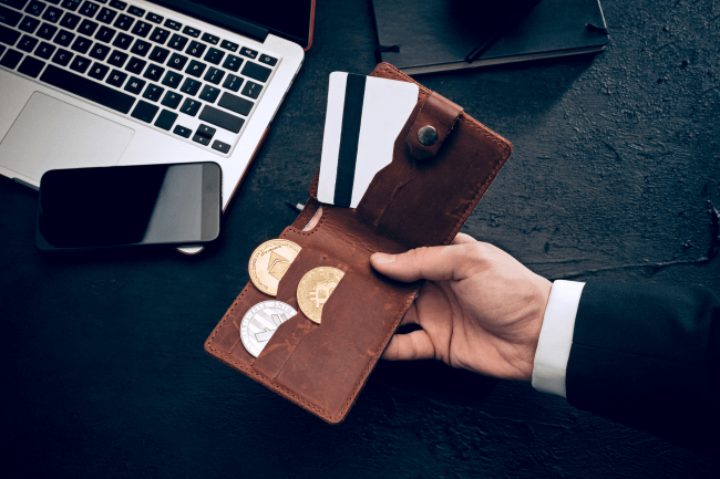 יד אוחזת בארנק עם קריפטו וכרטיס אשראי